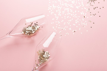 Christmas flat lay. Champagne glasses and gold decoration on pink background - Image