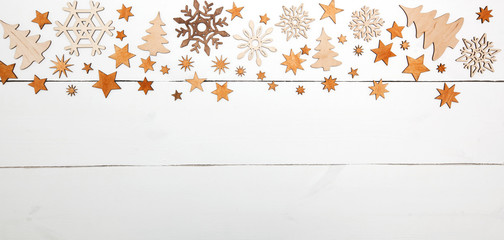 The beautiful christmas background with a lot of small wooden decorations on the white wooden desk.