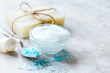 Fototapeta na wymiar blue sea salt, soap and body cream on stone desk background