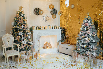 The Scandinavian style Christmas or New Year background: Christmas tree by the fireplace, golden glass balls and toys, wooden chair, wool blanket, sofa. Christmas studio interior. 