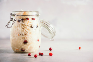 Sauerkraut in glass jar on grey background with copy space. Fermented and marinated cabbage at home. The best natural probiotic food
