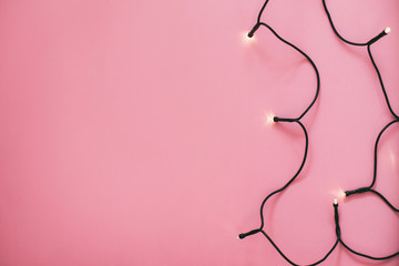 Golden Christmas garland on pink background.