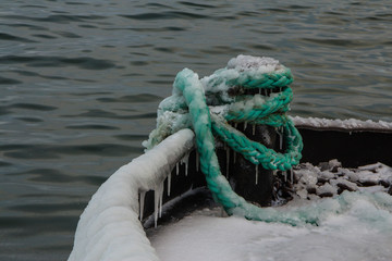 Fototapeta premium Frozen ropes on the pier near the Seaplane Harbour Museum in Tallinn in winter. Estonia