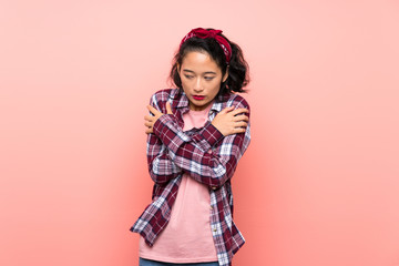 Obraz na płótnie Canvas Asian young woman over isolated pink background freezing