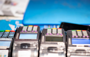 Close up of credit card payment terminal with blurred background in shopping mall. Various credit card machines on cashier counter in convenience store.