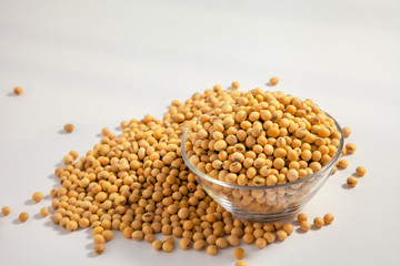 Soybeans background . Dry Soy bean or soya bean in a bowl with some soybeans in wooden spoon on white background