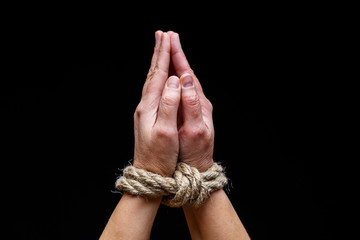 Woman with tied hands. Hands tied with rope on dark background. International Day for the Elimination of Slavery.