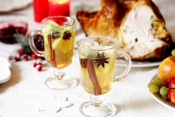 christmas hot cider. hot winter drink Cranberry Apple Cider Punch. Garnish with apples, oranges, and cranberries. hot apple cider with spices on a festive table on Christmas or New Year.