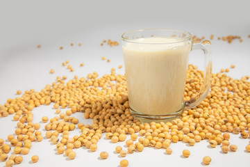 Soy milk pouring in glass and soy bean or soya bean . Alternative Soy milk healthy concept.