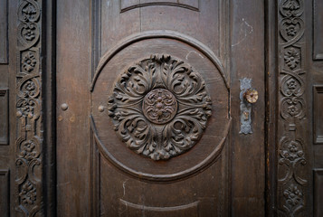 Fragment of an old door decorated with wood carvings.