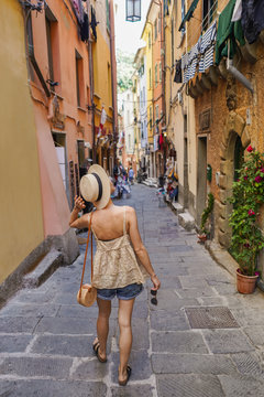 Fototapeta Back view of tourist woman walking in italian street
