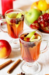 hot winter drink Cranberry Apple Cider Punch. Garnish with apples, oranges, and cranberries. hot apple cider with spices on a festive table on Christmas or New Year.