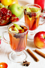 hot winter drink Cranberry Apple Cider Punch. Garnish with apples, oranges, and cranberries. hot apple cider with spices on a festive table on Christmas or New Year.