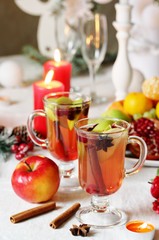 hot winter drink Cranberry Apple Cider Punch. Garnish with apples, oranges, and cranberries. hot apple cider with spices on a festive table on Christmas or New Year.