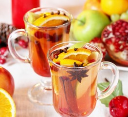 hot winter drink Cranberry Apple Cider Punch. Garnish with apples, oranges, and cranberries. hot apple cider with spices on a festive table on Christmas or New Year.