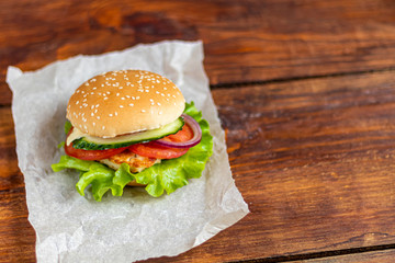 Sandwich with chicken cutlet. The roll is sprinkled with sesame seeds on top. Hamburger.