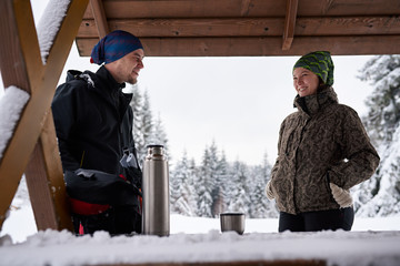 Couple drinking coffee during a break from their winter hike