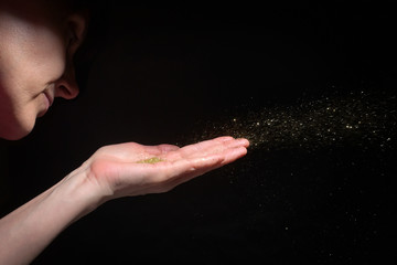 Woman Hand Blowing Glitter Sparkles
