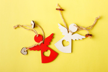 Decorative angel shaped wooden toys, yellow background