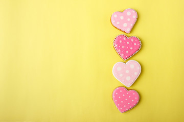 Pink cookie heart shaped with different patterns, yellow background
