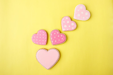 Pink cookie heart shaped with different patterns, yellow background