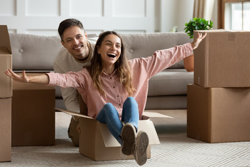 Happy  young couple riding in box on moving day