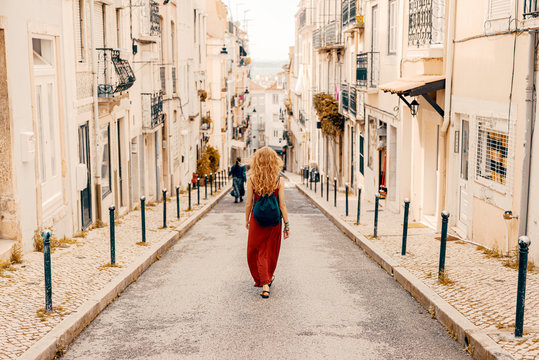 Fototapeta Young women walking through narrow Lisbon street