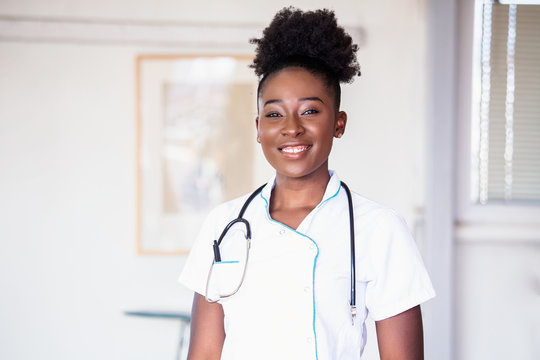 African American Doctor working in hospital , Healthcare and medical concept Stethoscope around her neck. Female black doctor filling up medical form at clipboard while standing straight in hospital