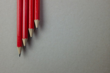 Four graphite pens viewed from above placed diagonally from top to bottom with plain gray background