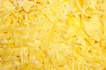 Grated yellow cheese close-up view from above. Background image of ingredients for Italian pizza. The texture of grated cheese. Flat lay и  copy space.