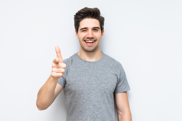 Young happy man pointed with finger on you isolated on white background