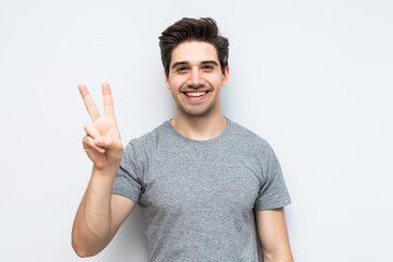 Young handsome man with peace gesture isolated on white background