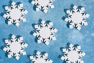 Christmas and New Year pattern made of wooden snowflakes on a blue background. Christmas, winter, new year concept. Flat lay, top view