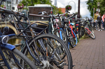 Fototapeta na wymiar Amsterdam, Holland. August 2019. Bicycles parked along the canals are a symbol of the city. A bike with a red racing frame stands out among the others.