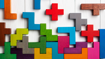 Top view on colorful wooden blocks folding on white wooden background