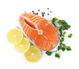 Fresh raw salmon with pepper, lemon and parsley on white background, top view. Fish delicacy