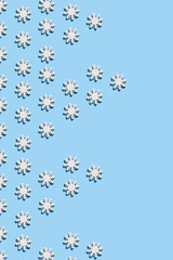 Christmas and New Year pattern made of wooden snowflakes on a blue background. Christmas, winter, new year concept. Flat lay, top view, copy space