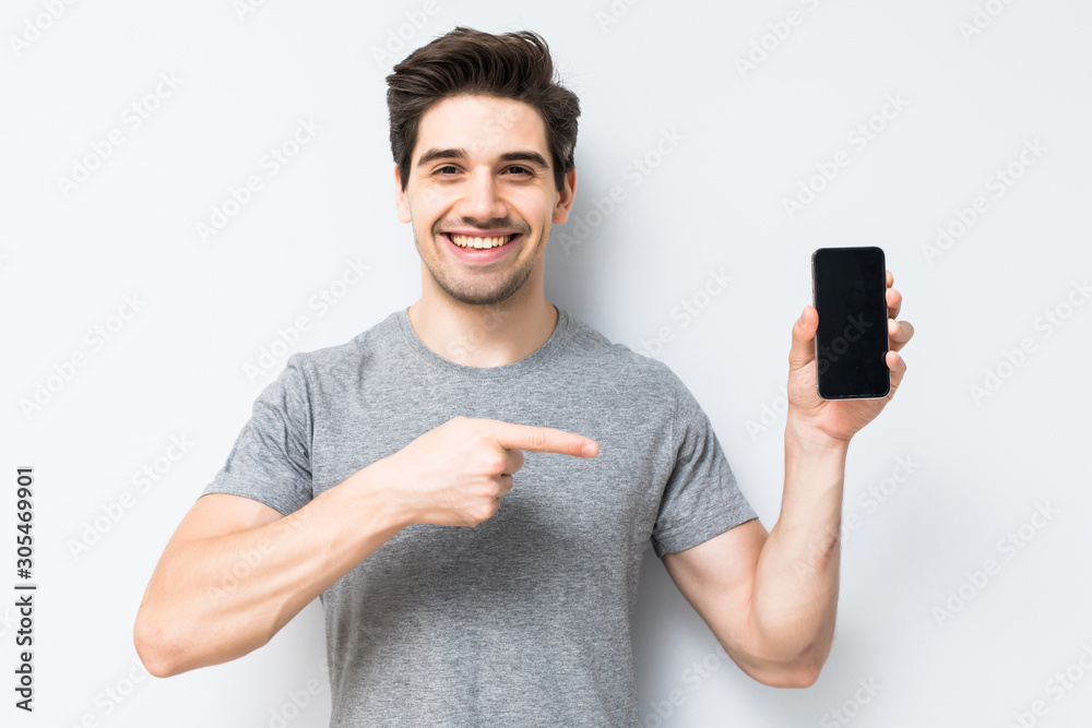 Wall mural portrait of a smiling man showing blank smartphone screen isolated on white background