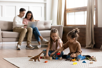 Happy family with cute kids daughters relax in living room