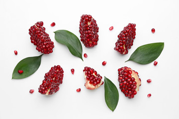 Pieces of ripe tasty pomegranate on white background