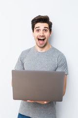 Portrait of young man with laptop isolated on white. Concept communication.