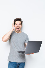 Portrait of young man with laptop isolated on white. Concept communication.