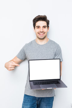 Young Man Presenting Laptop On White Screen Isolated On White Background