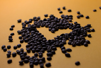 coffee beans on orange background with heart silhouette