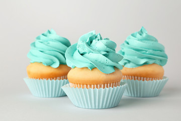 Tasty cupcakes on grey background