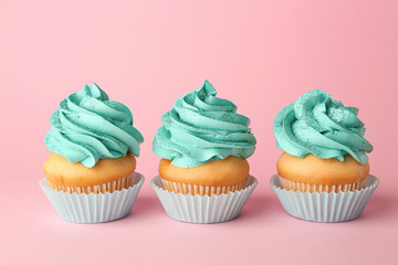 Tasty cupcakes on color background