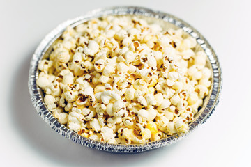Popcorn in a foil bowl on a white background