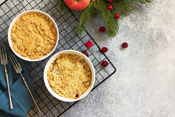 Homemade winter dessert. Apple crumbles with cranberries on a stone or slate countertop background. Top view of a flat lay. Copy space.