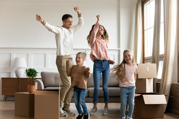 Funny parents and kids dancing celebrating moving day