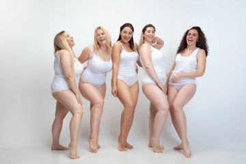 In love with myself. Portrait of beautiful plus size young women posing on white background. Happy...